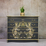 Load image into Gallery viewer, Petit a Petit Redesign with Prima Transfer from the Kacha Collection featuring gold scrolls and pretty pink roses and flowers on a dramatic black and gold sideboard
