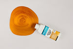 Load image into Gallery viewer, Bottle of Antique Gold Polyvine Metallic Paint being poured onto a pale grey surface
