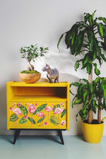 Load image into Gallery viewer, Flamingo Pink Redesign with Prima Small Transfer - flamingos, tropical banana-style leaves and monstera leaves plus vibrant pink hibiscus flowers. A statement design on a bright yellow side cabinet.
