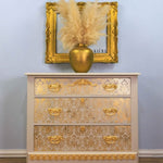 Load image into Gallery viewer, Renata Floral Damask Redesign with Prima Stencil feom the Kacha Collection in gold on a beige chest of drawers
