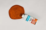 Load image into Gallery viewer, Bottle of Copper Polyvine Metallic Paint being poured onto a pale grey surface
