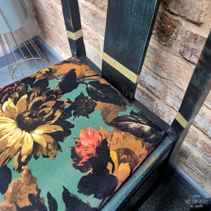 Black chair with green details and floral sunflower fabric seat pads