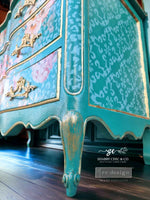 Load image into Gallery viewer, Gothic Trellis Redesign with Prima Stencil on the side of a bright turquoise chest of drawers

