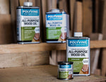 Load image into Gallery viewer, Polyvine All Purpose Wood Oil range of 4 size tins in a workshop 
