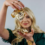 Load image into Gallery viewer, Kacha holding sheets of her Redesign with Prima imitation gold leaf sheets
