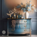 Load image into Gallery viewer, In The Field Redesign with Prima Copper Rose Gold Foil Transfer from the Kacha Collection featuring cascading leaves on a blended blue and taupe chest of drawers
