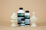Load image into Gallery viewer, The 3 sizes of Polyvine acrylic crackle glaze on a beige background with decorative white vases showing the crackle effect
